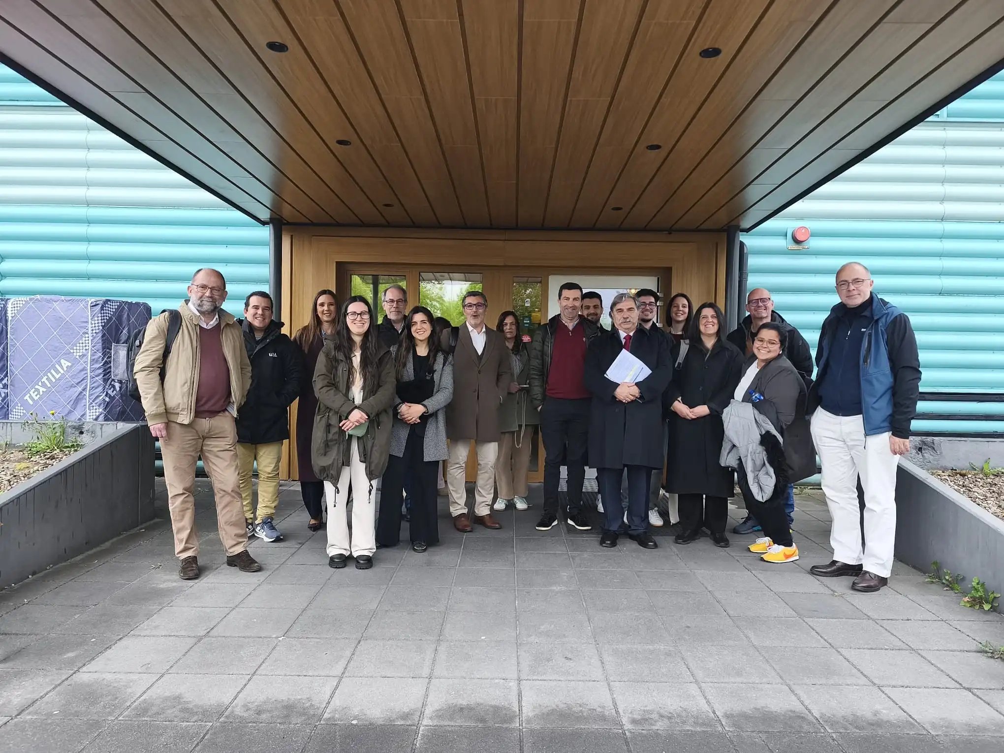 Participantes numa visita institucional do CNIPES, reunidos no exterior de um edifício universitário no âmbito da inovação pedagógica no ensino superior.