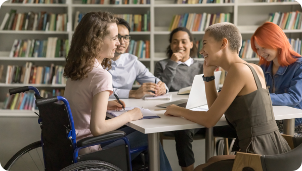 Grupo de estudantes trabalha em conjunto com recurso a portátil sobre bem-estar, inclusão e sucesso.