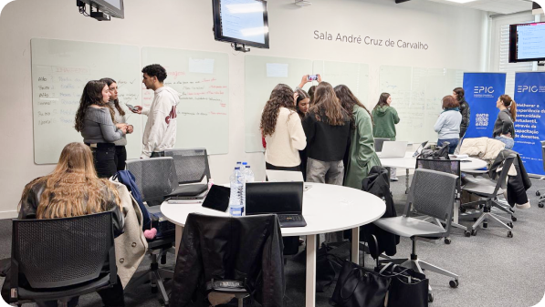 Participantes organizados por mesas numa sessão de trabalho com apoio de um formador dos centros de inovação pedagógica.
